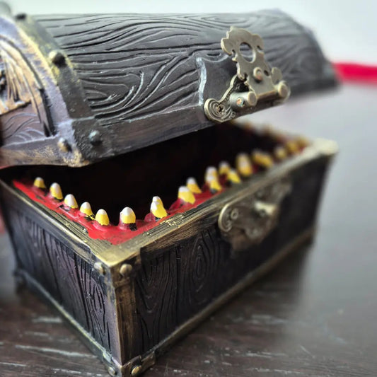 A brown ang gold mimic chest for dice storage With red and black painted mimic with teeth inside