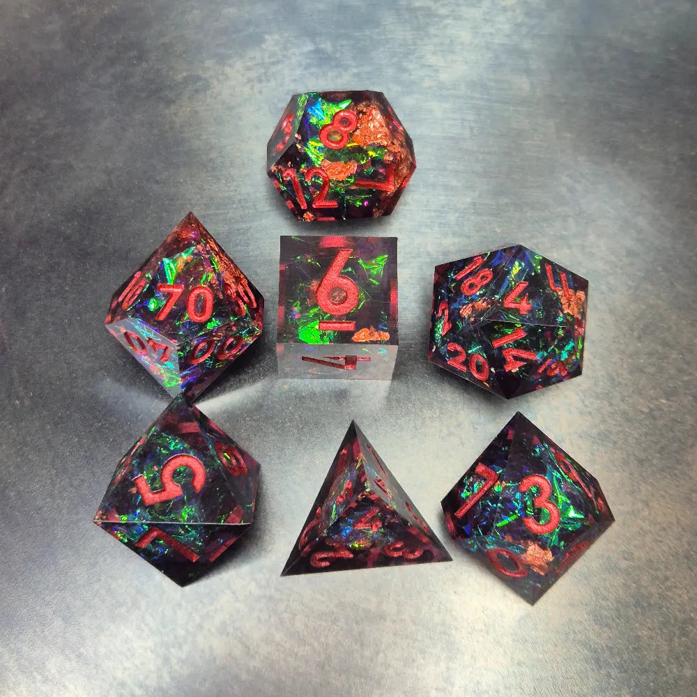 A set of clear purple tinted sharp edge resin dice with colourfull confetti inside on a blue metal surface