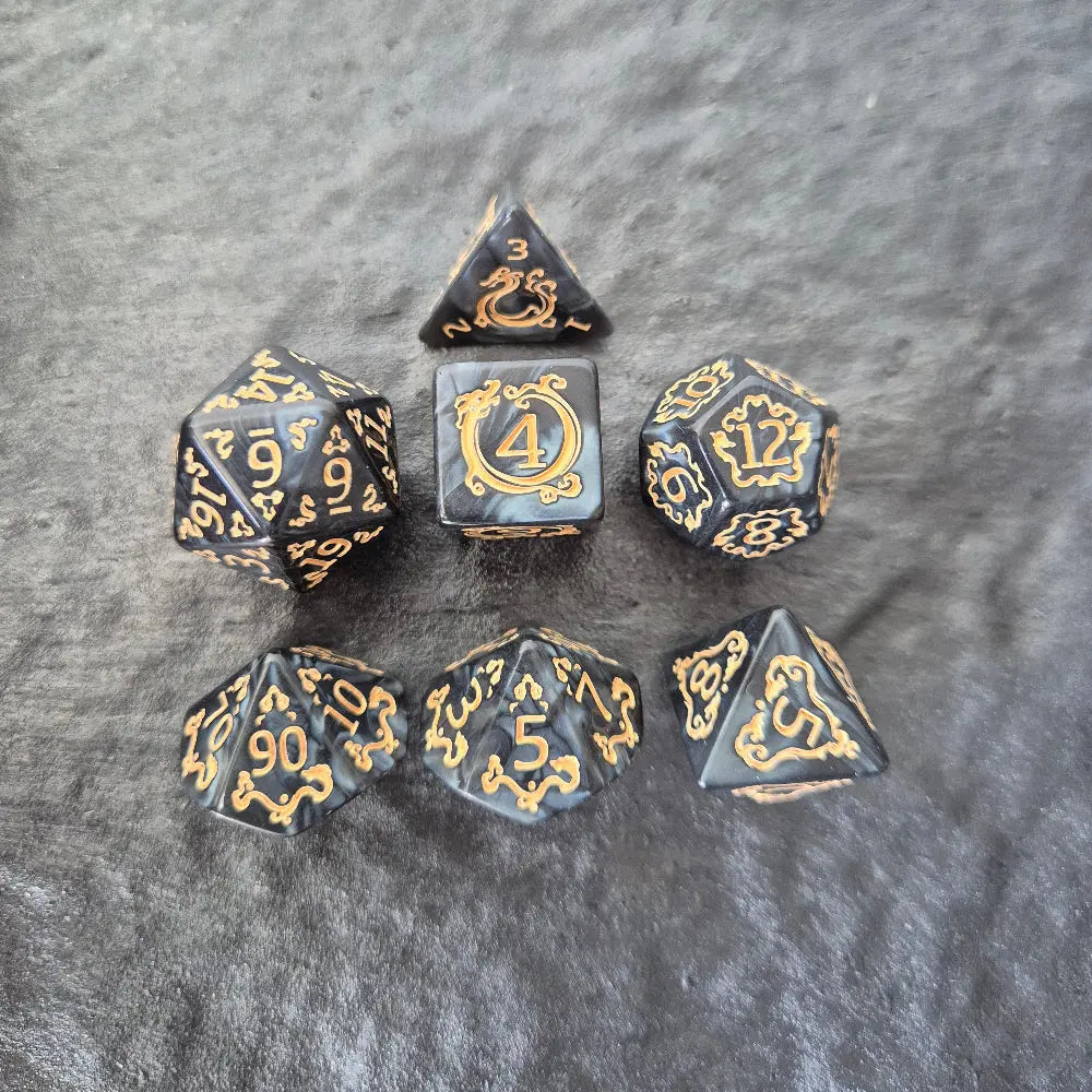 Acrylic D&D dice set with swirling black design and ornate golden numbering, displayed on a dark background.