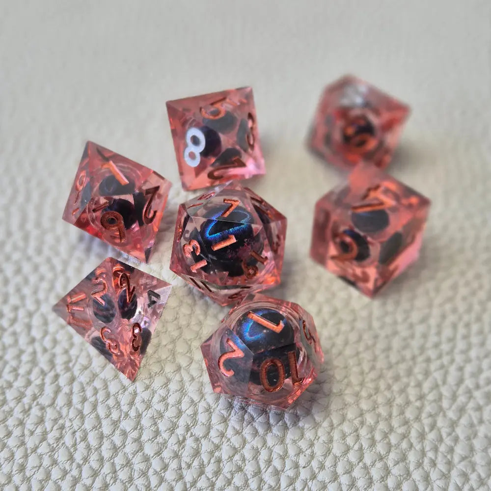 A set of red tinted clear liquid core dice with a moving dragon eye inside on a white textured background