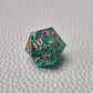 A set of turquoise tinted clear sharp edge resin dice filled with gold flakes. Displayed on a white textured surface