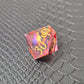 A set of clear red tinted liquid core resin dice with a moving dragon eye inside, displayed on a black textured surface