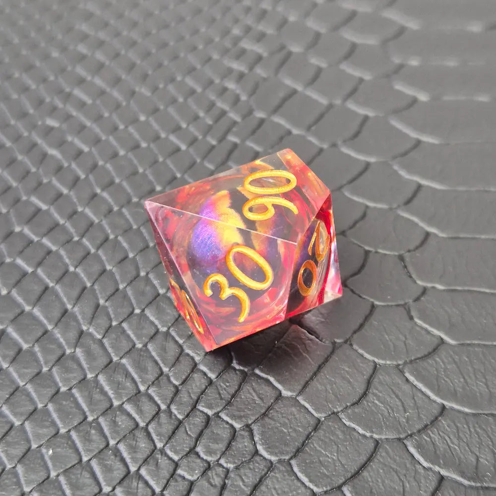 A set of clear red tinted liquid core resin dice with a moving dragon eye inside, displayed on a black textured surface