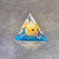 Whimsical sharp-edge D4 with floating yellow ducks and pink numbering, set in clear resin over a blue water-like base.