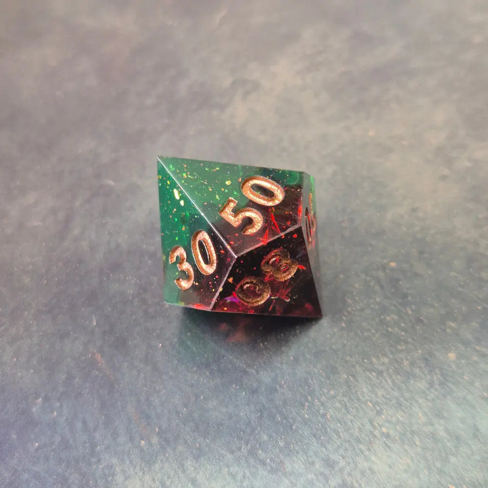 A set of Green and red sharp edge dice filled with sparkles and gold numbers.