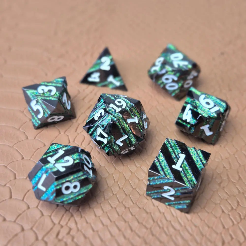 A set of black metal dice with shimmering green stripes and white numbering, displayed on a textured surface.