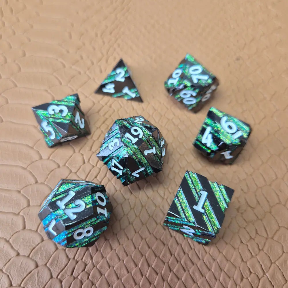 A set of black metal dice with shimmering green stripes and white numbering, displayed on a textured surface.