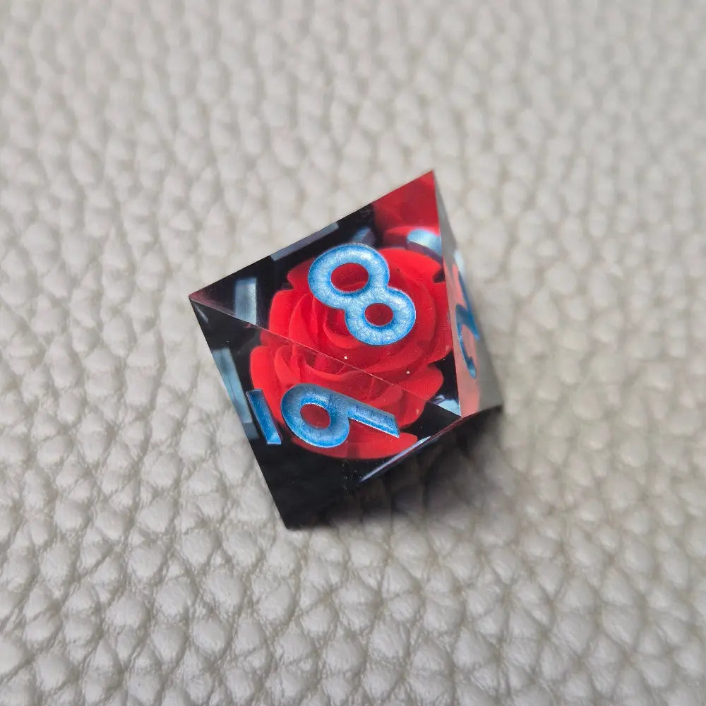 A set of clear sharp-edge resin dice with black ground color and red rose inside.