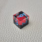 A set of clear sharp-edge resin dice with black ground color and red rose inside.