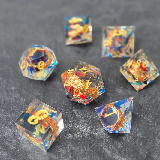 A set of clear blue tinted sharp edge resin dice with an engraved golden ring inside on a black surface