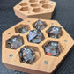 A Wooden Hexagon shaped dice storage box with magnets on a black textured surface