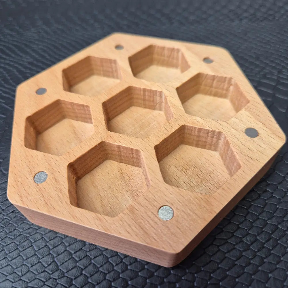 A Wooden Hexagon shaped dice storage box with magnets on a black textured surface