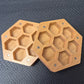 A Wooden Hexagon shaped dice storage box with magnets on a black textured surface