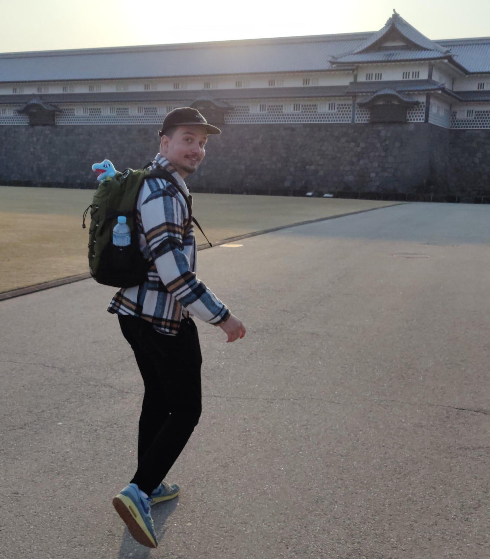 Man walking on a paved area with a building in the background