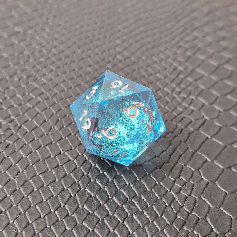 A set of clear light blue tinted liquid core dice with koi fish and glitters inside, displayed on a black textured surface