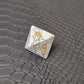 D8 white marble-textured gemstone die with gold numbering, displayed on a black leather surface.