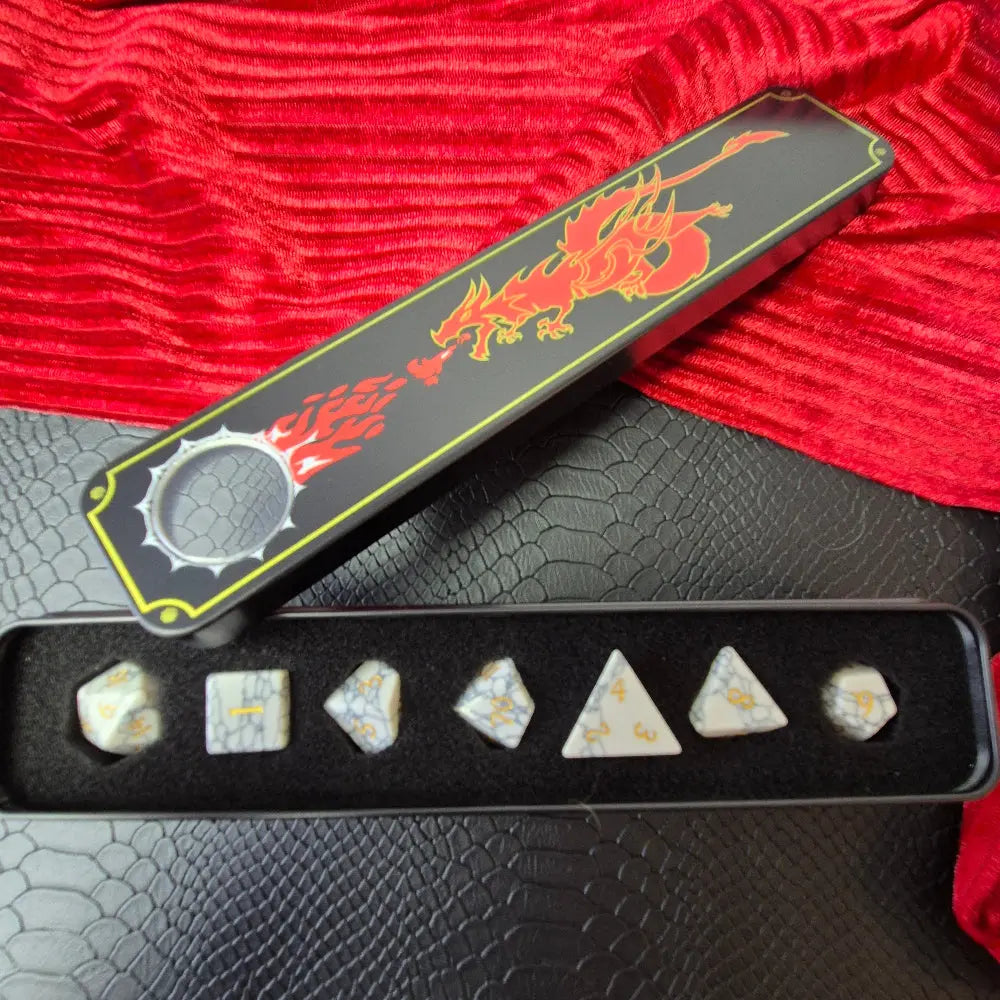 Set of white marble-textured gemstone dice with gold numbering, displayed on a black leather surface.