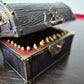 A brown ang gold mimic chest for dice storage With red and black painted mimic with teeth inside