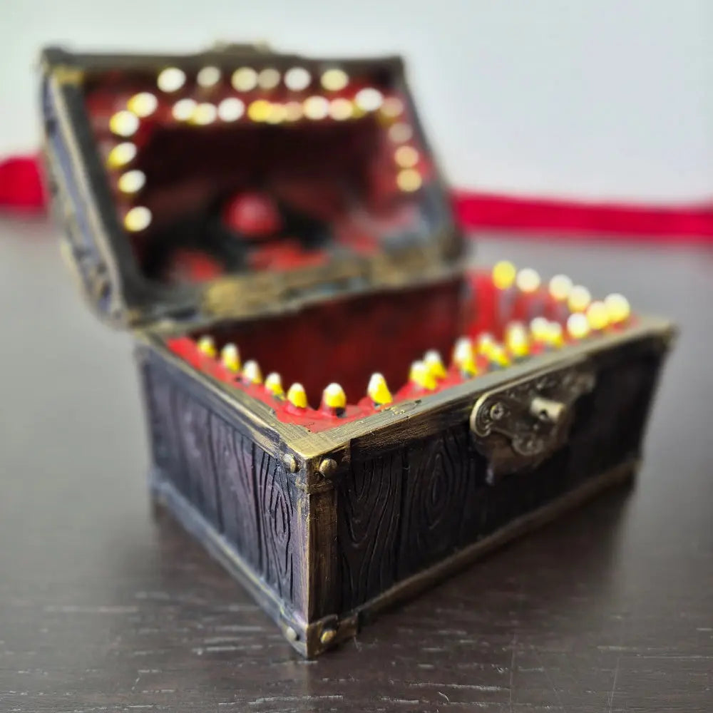 A brown ang gold mimic chest for dice storage With red and black painted mimic with teeth inside