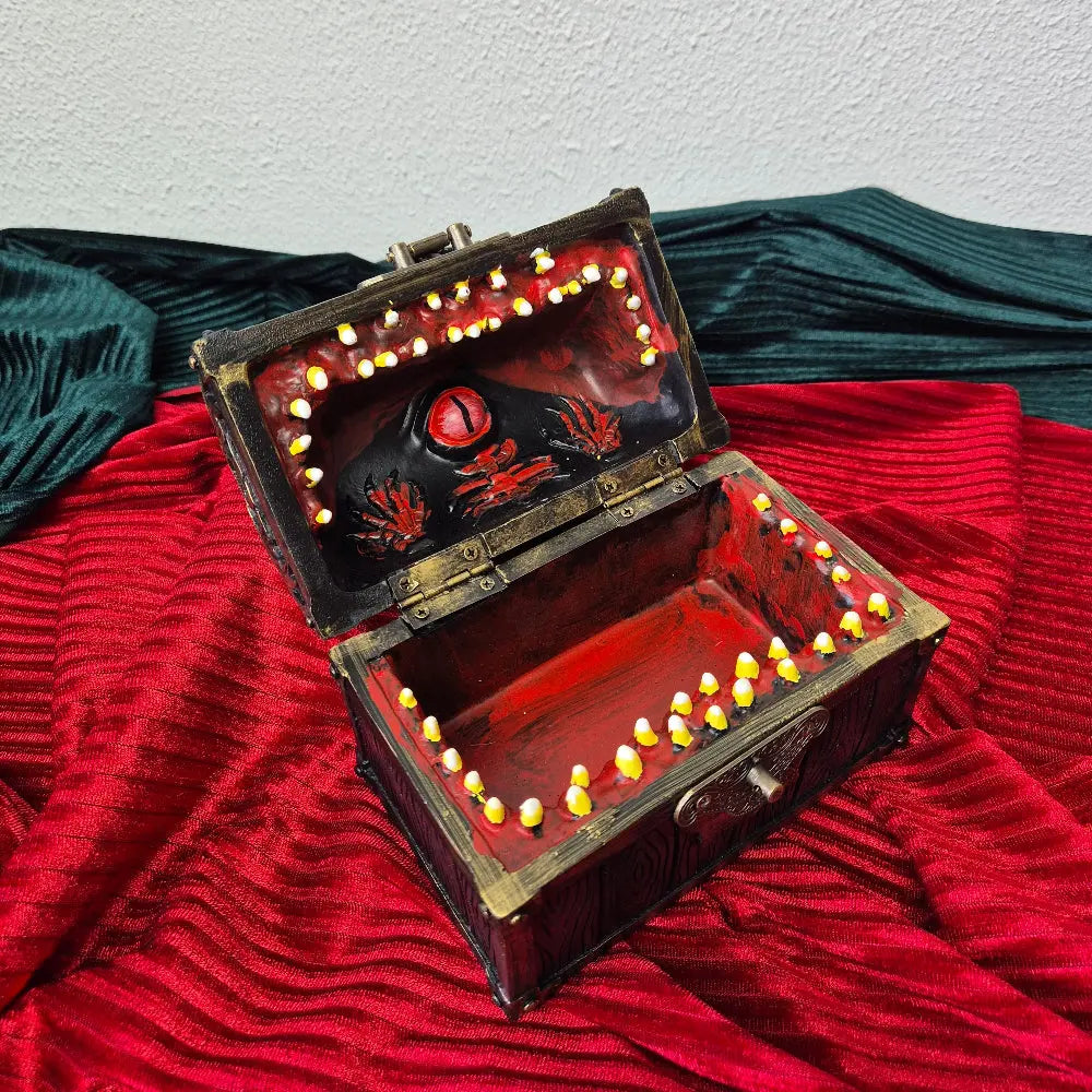 A brown ang gold mimic chest for dice storage With red and black painted mimic with teeth inside