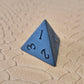 A set of matte black/ dark grey gemstone dice on a beige textured surface