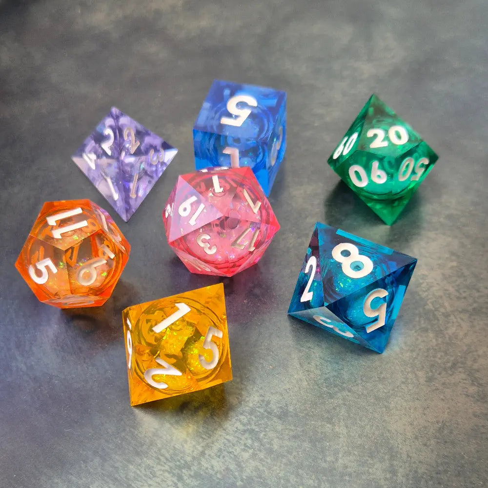 A set of rainbow coloured resin dice witch liquid core displayed on metal plate