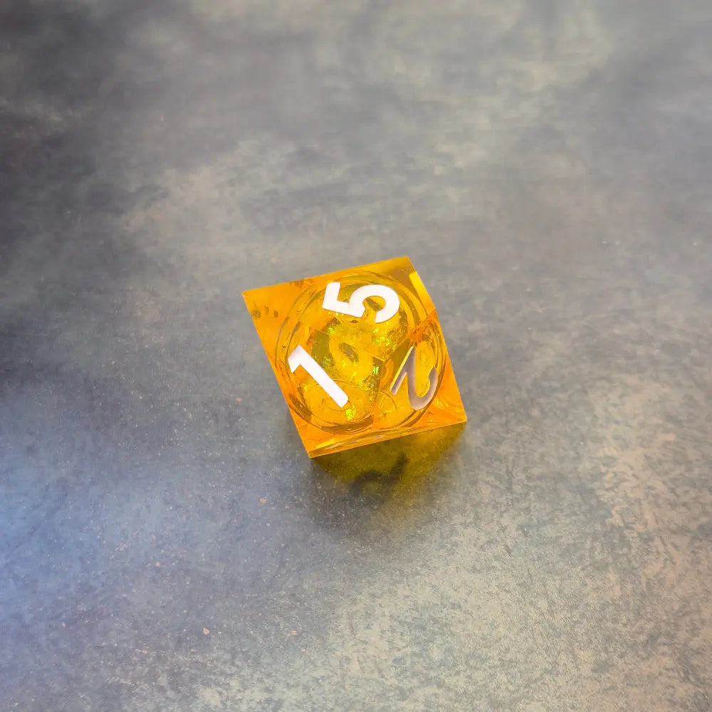 A set of rainbow coloured resin dice witch liquid core displayed on metal plate