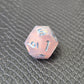 A set of pink sharp edge resin dice with blue numbers on a black textured surface