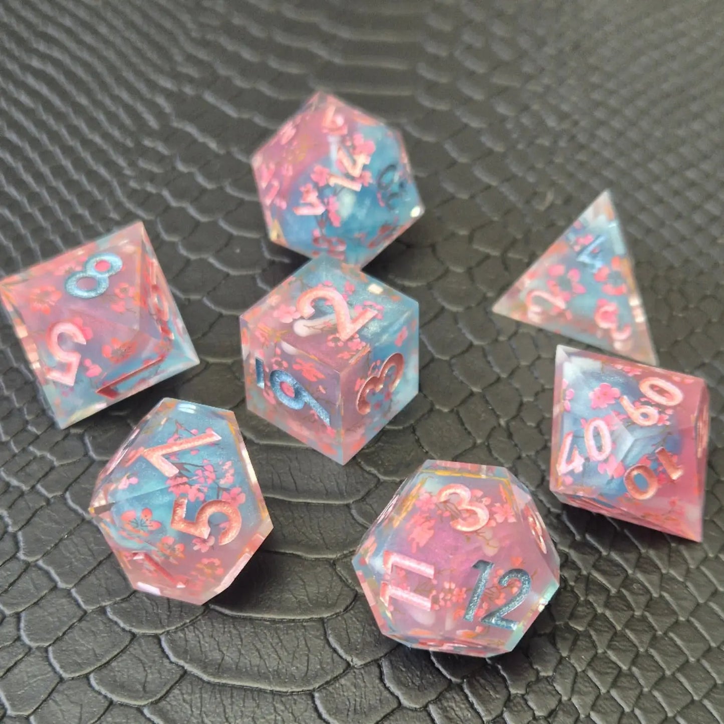Sharp edge resin dice set. Pink and blue with sakura flowers and black textured blackground