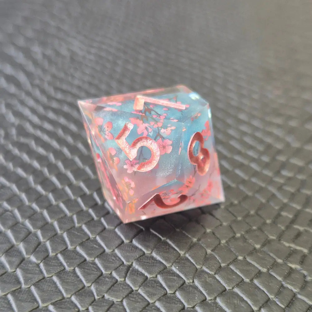 Sharp edge resin dice set. Pink and blue with sakura flowers and black textured blackground