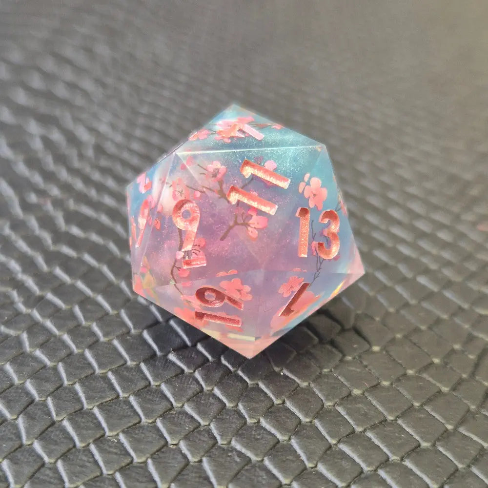 Sharp edge resin dice set. Pink and blue with sakura flowers and black textured blackground