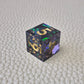 A set of blue sharp edge resin dice with green confetti inside on a white textured surface