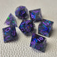 A set of purple sharp edge resin dice with blue confetti inside on a white textured surface