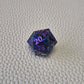 A set of purple sharp edge resin dice with blue confetti inside on a white textured surface