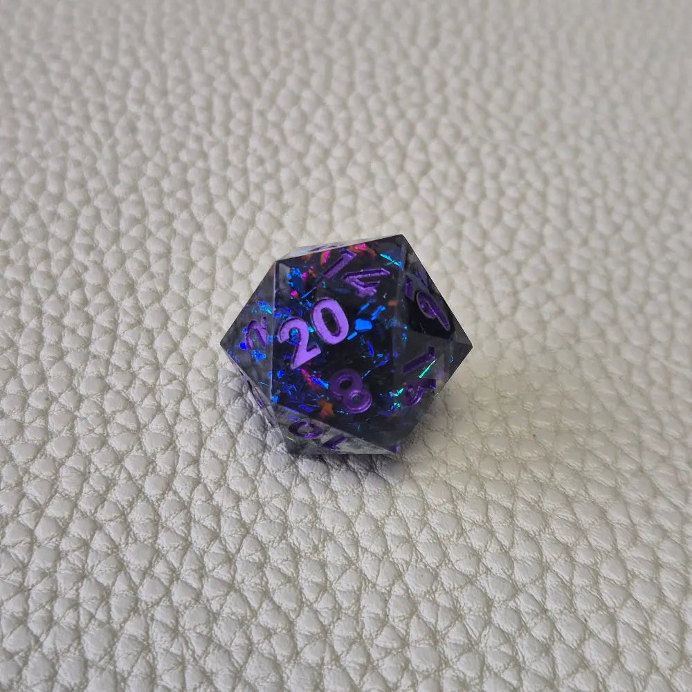 A set of purple sharp edge resin dice with blue confetti inside on a white textured surface