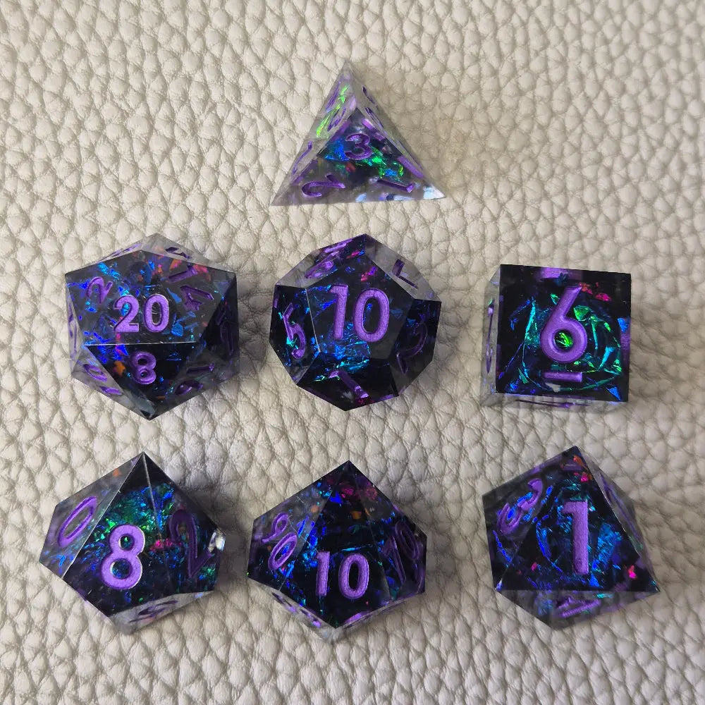 A set of purple sharp edge resin dice with blue confetti inside on a white textured surface