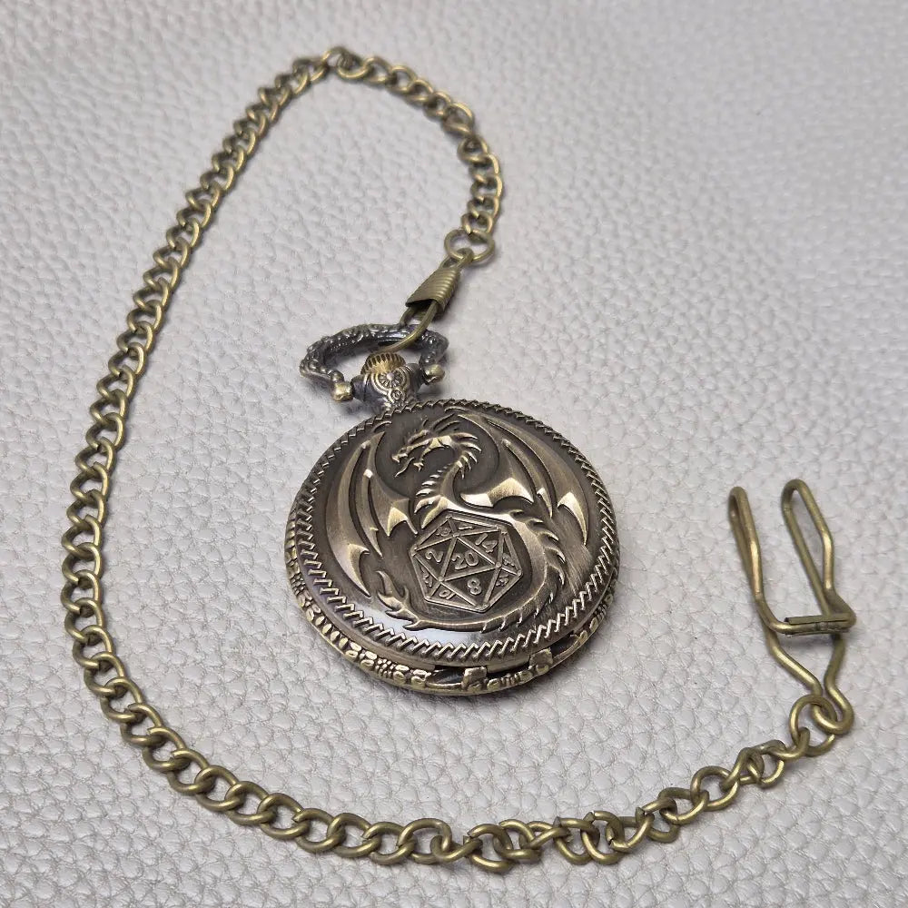 A Bronze coloured full metal pocket watch themed dice locket, with engraved backside and detailed dragon on the front. Contains full set of metal dice inside