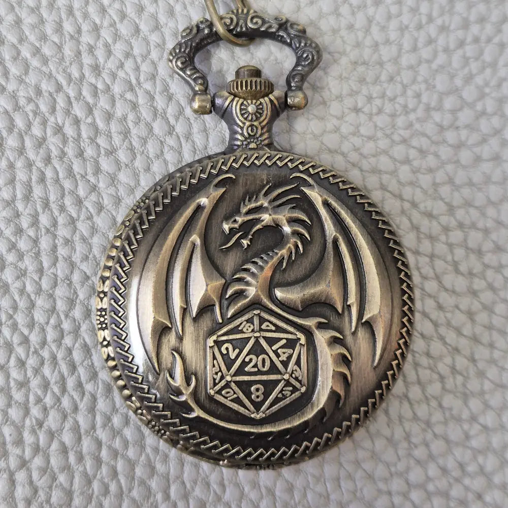 A Bronze coloured full metal pocket watch themed dice locket, with engraved backside and detailed dragon on the front. Contains full set of metal dice inside