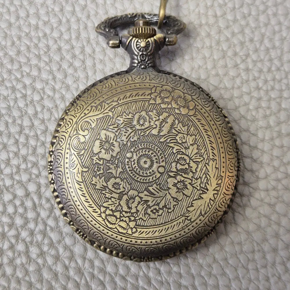A Bronze coloured full metal pocket watch themed dice locket, with engraved backside and detailed dragon on the front. Contains full set of metal dice inside