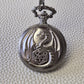 A silver coloured full metal pocket watch themed dice locket, with engraved backside and detailed dragon on the front. Contains full set of metal dice inside