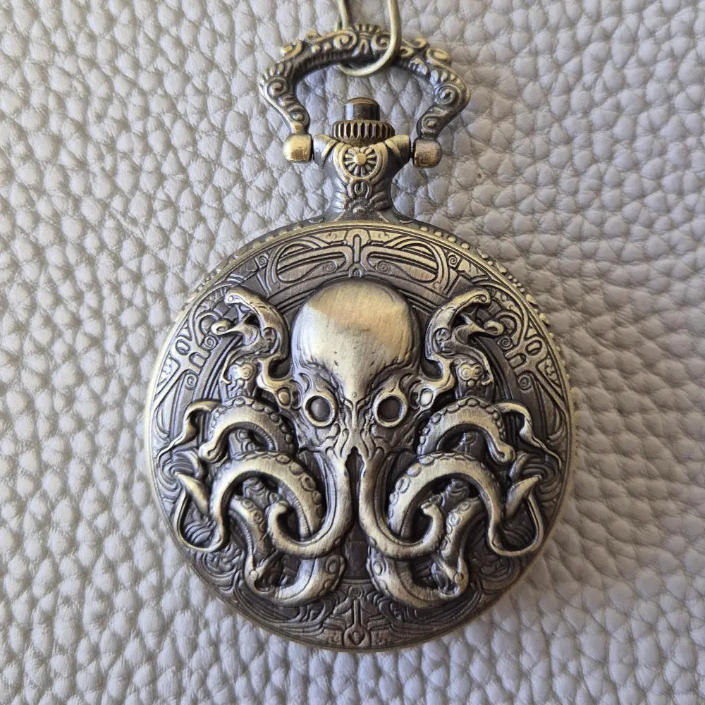 A Bronze coloured full metal pocket watch themed dice locket, with engraved backside and detailed kraken on the front. Contains full set of metal dice inside