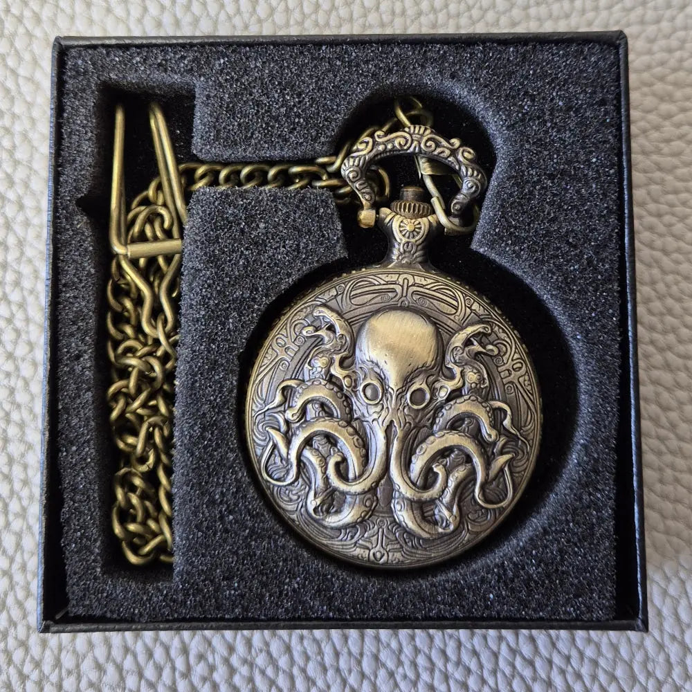 A Bronze coloured full metal pocket watch themed dice locket, with engraved backside and detailed kraken on the front. Contains full set of metal dice inside