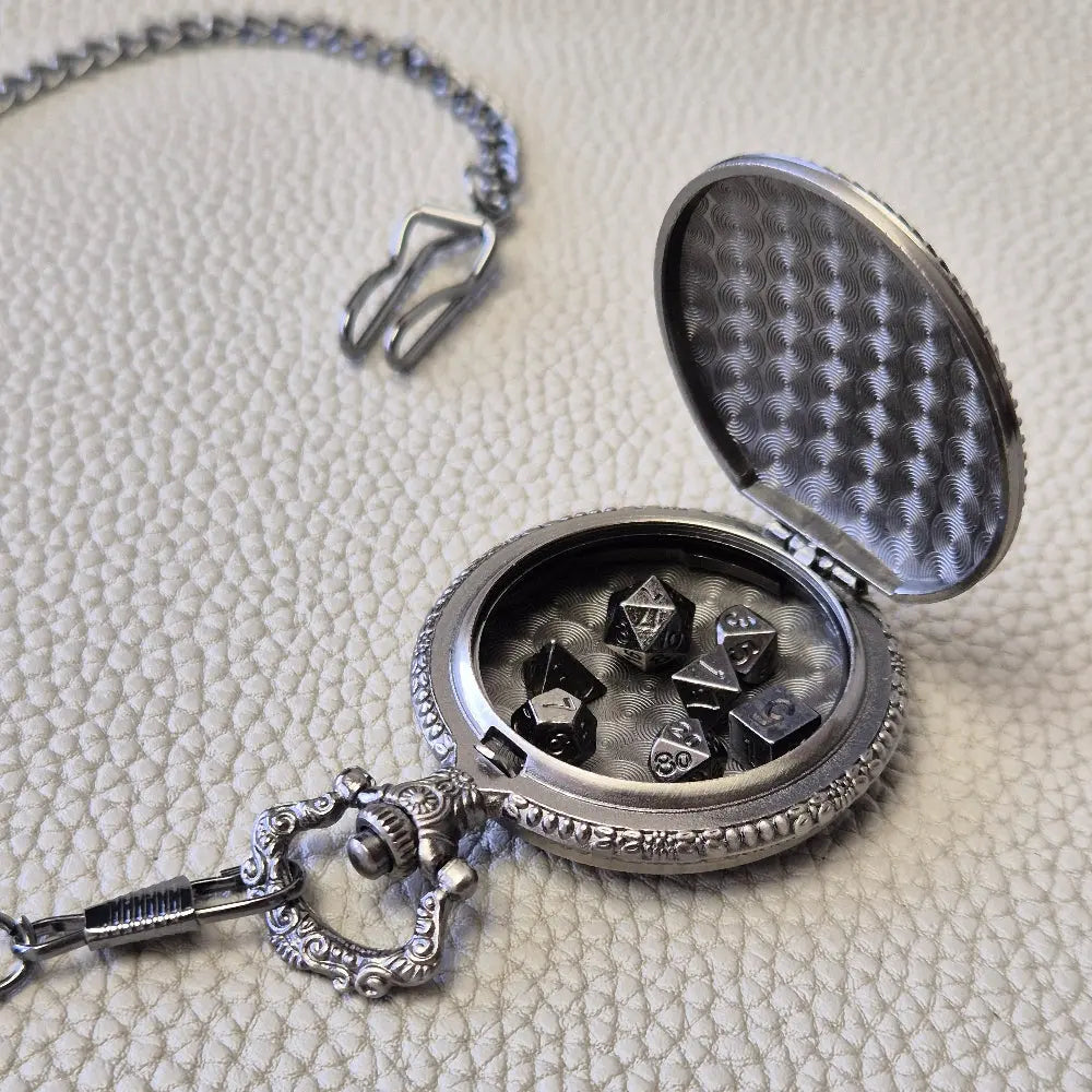 A silver coloured full metal pocket watch themed dice locket, with engraved backside and detailed kraken on the front. Contains full set of metal dice inside