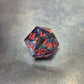 A set of clear purple tinted sharp edge resin dice with colourfull confetti inside on a blue metal surface