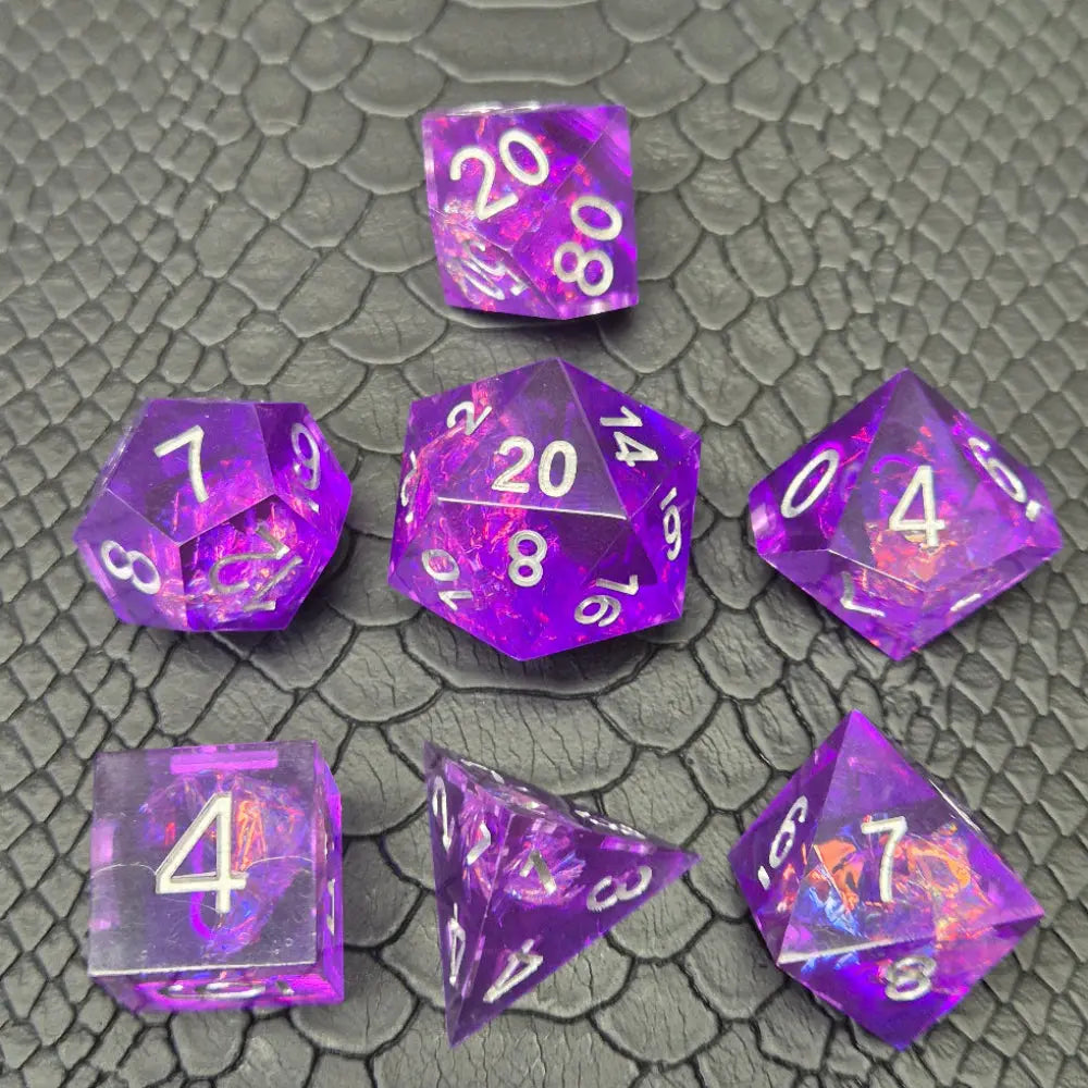 A set of sharp-edge purple resin dice and silver numbering, displayed on a black scale-textured surface.