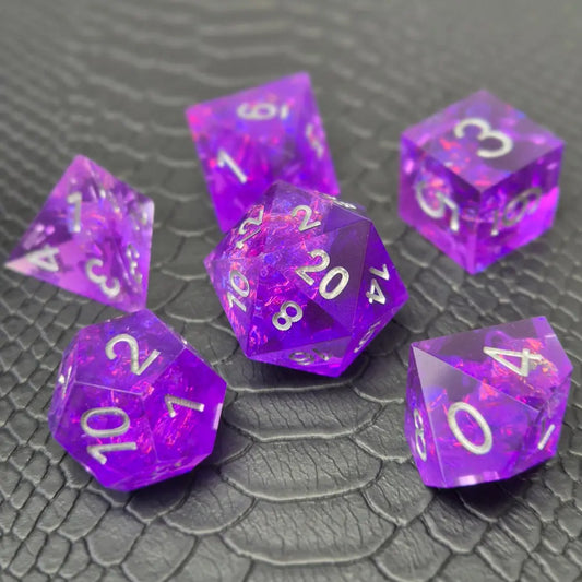A set of sharp-edge purple resin dice and silver numbering, displayed on a black scale-textured surface.