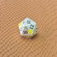 Metal D&D dice set with matte silver finish and painted yellow flowers, displayed on textured leather background.