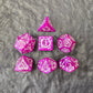 Purple acrylic polyhedral dice set with white ornate numbering, styled with arcane fantasy motifs, displayed on a stone surface.