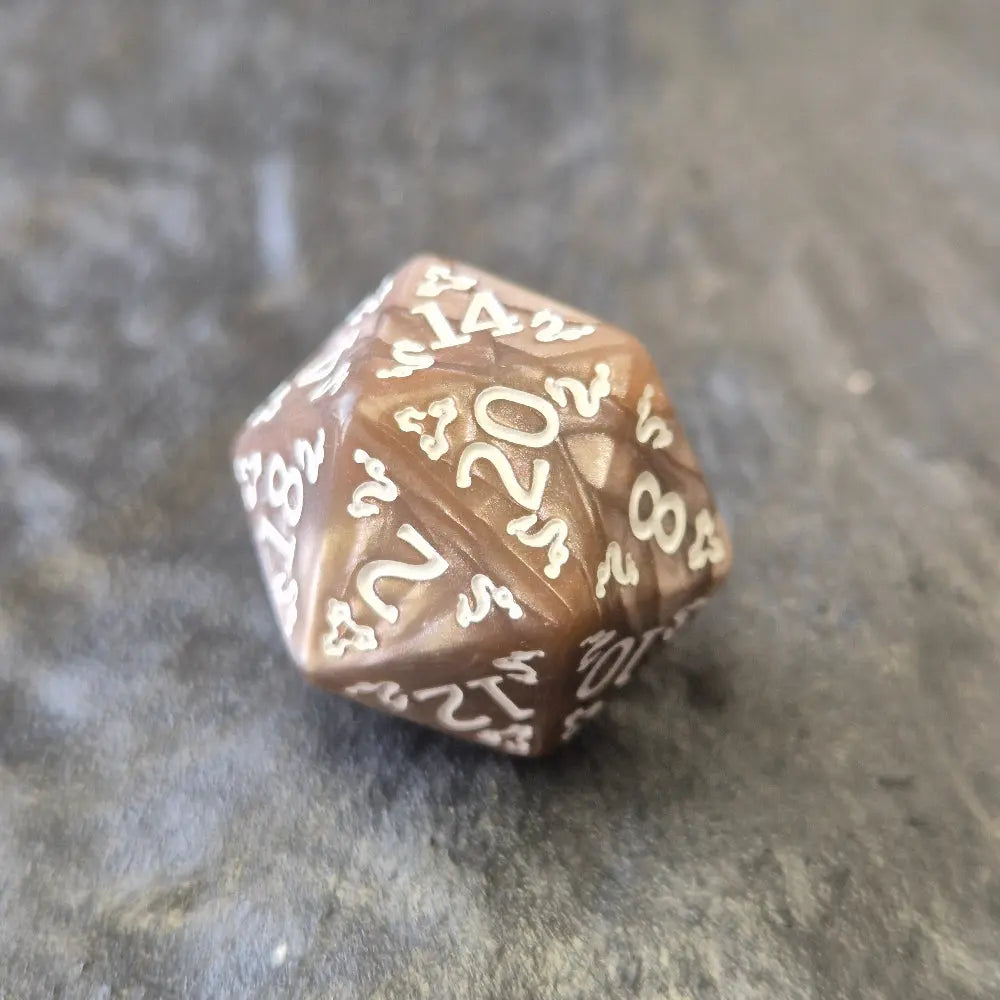 Brown khaki acrylic D20 with white ornate numbers, arranged on a textured grey stone background.