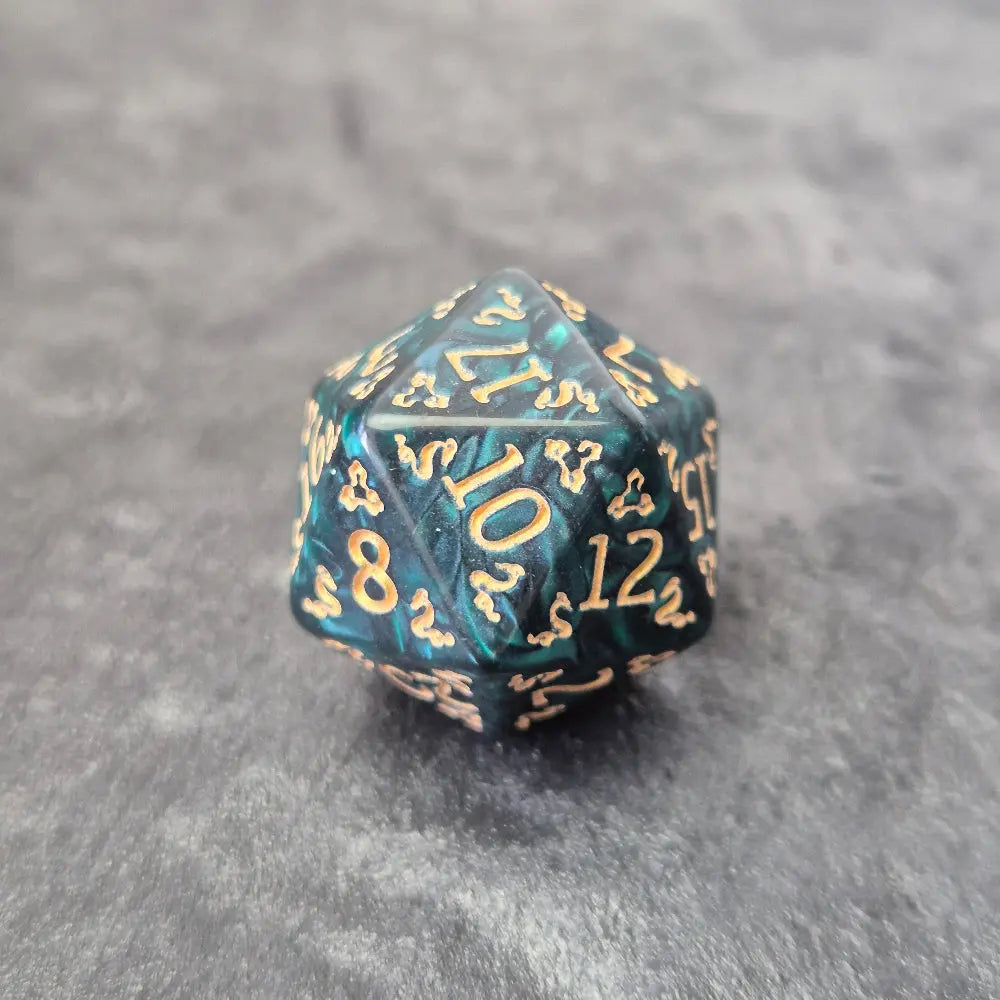 Acrylic D20 with emerald green swirls and antique gold arcane-style numbering, displayed on a textured dark surface.